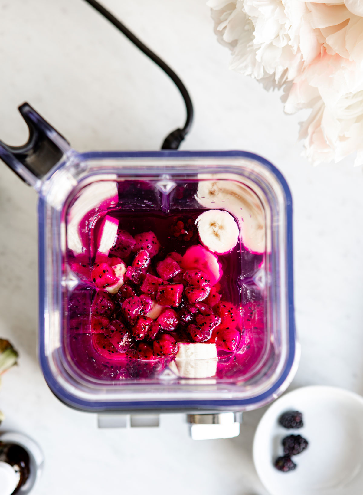 Overhead view of bananas and dragonfruit in a blender to make elderberry smoothie.