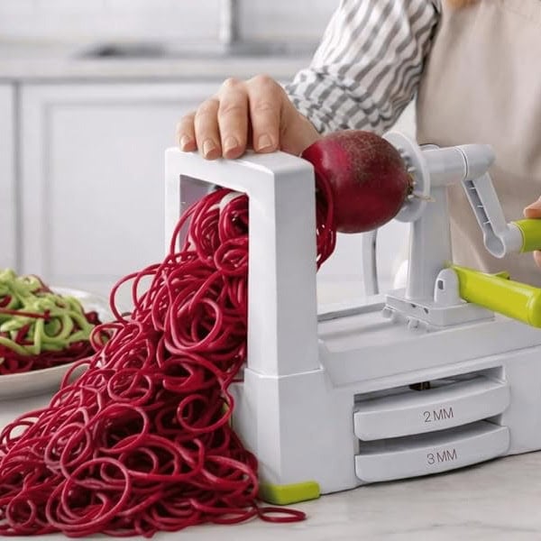 Vegetable spiralizer turning beet into noodles for healthy recipes.