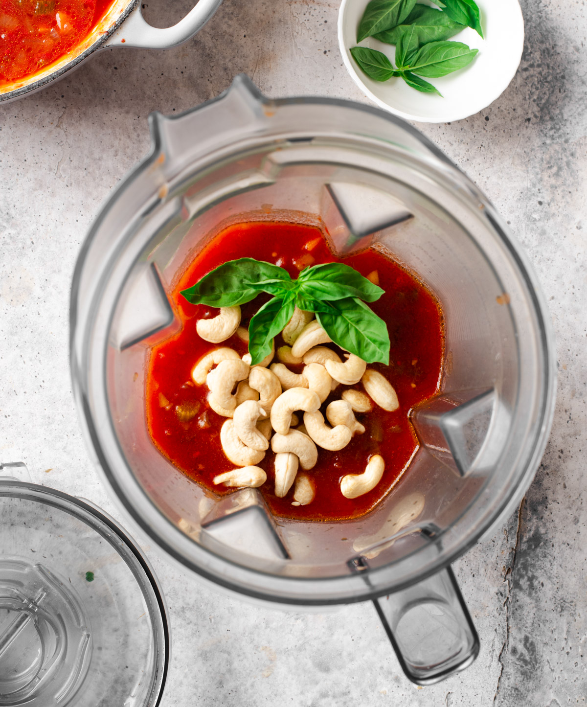 Blending cashews and fire-roasted tomato soup in a blender.