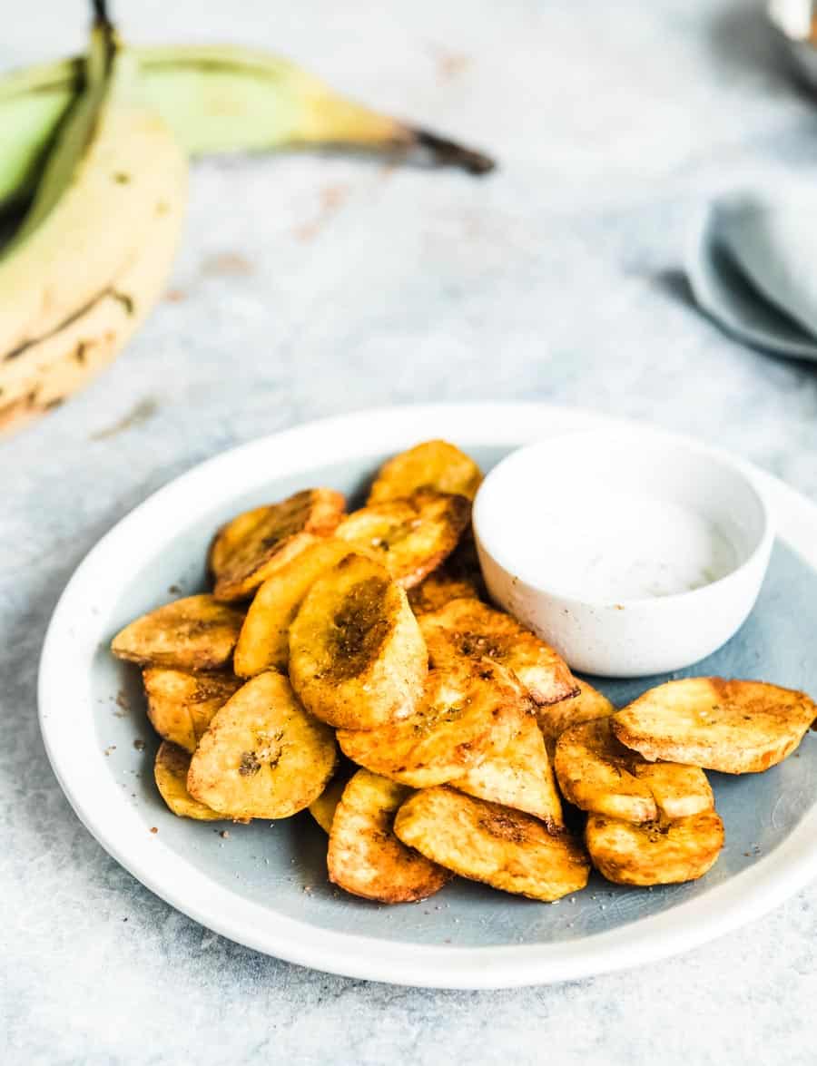 fried sweet plantains with a bowl of maple cashew cream on a plate.