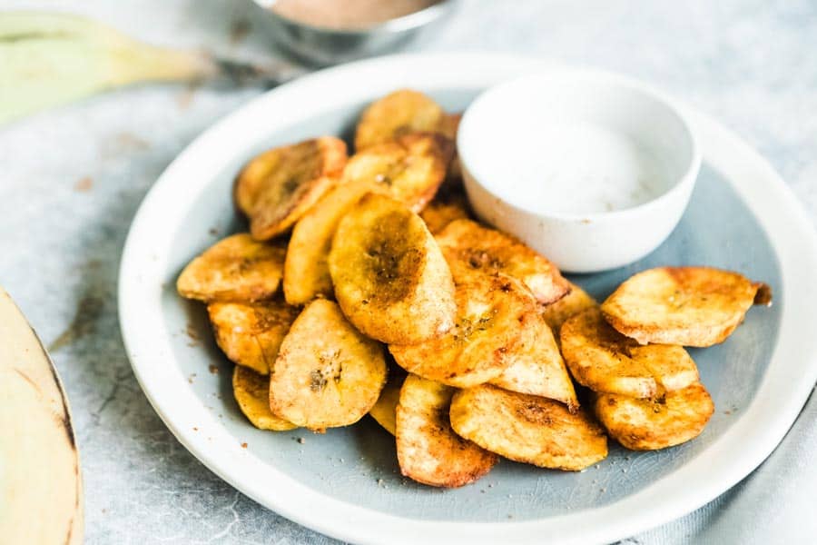 plate of fried plantains with a white bowl of maple cashew cream.