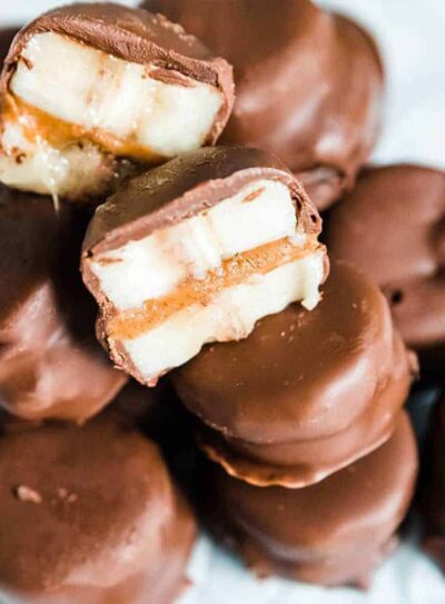 Frozen chocolate covered banana bites stacked on plate.
