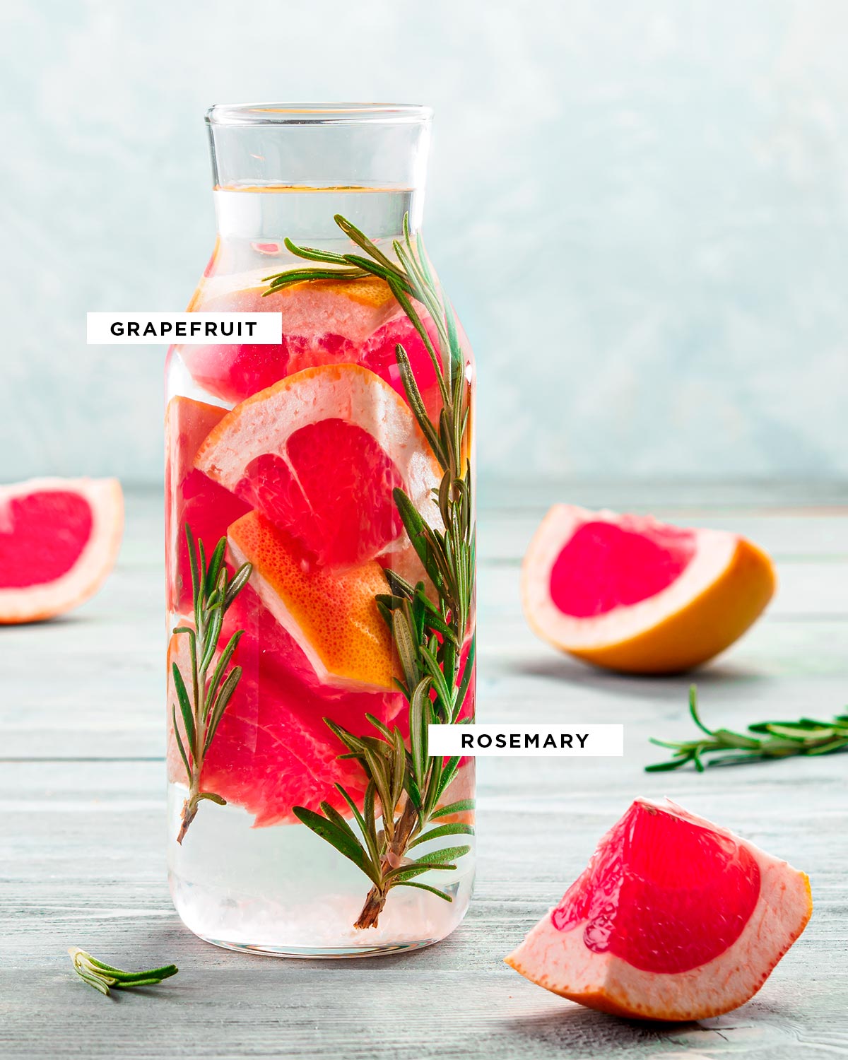 labeled ingredients for detox water including grapefruit and rosemary in a liter-sized glass container.