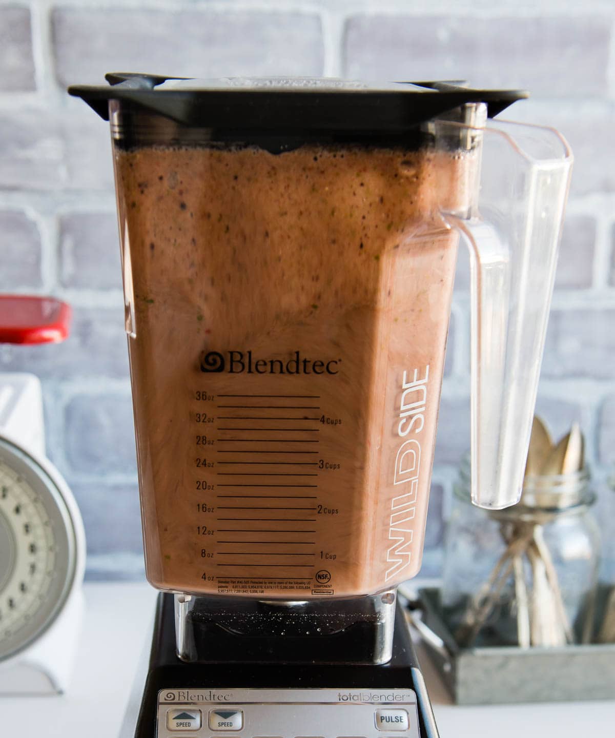 side photo of a Blendtec blender in the middle of blending a smoothie bowl