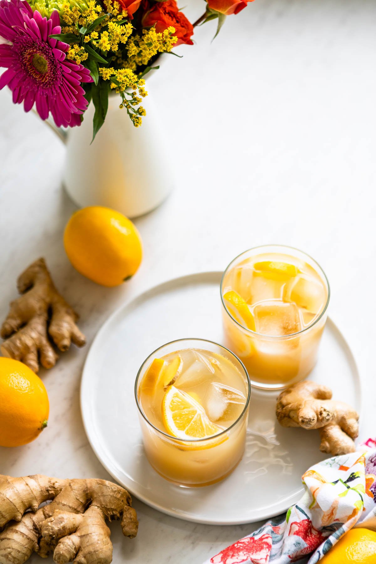 Two glasses of ginger switchel recipe, nature's gatorade, on a plate.