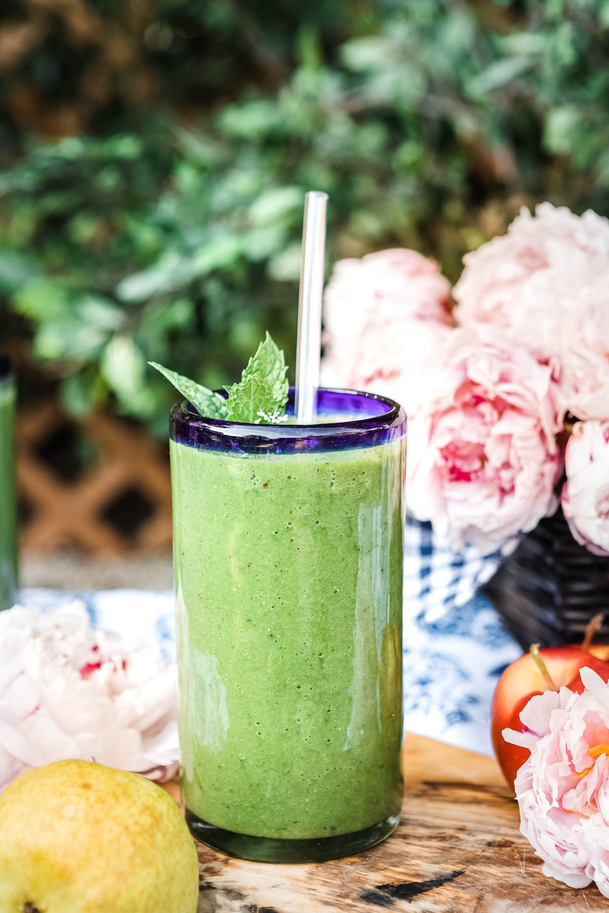 glass of green smoothie with glass straw.