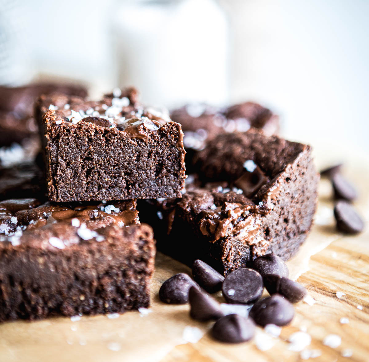 stack of dairy free brown squares topped with coarse salt and vegan chocolate chips