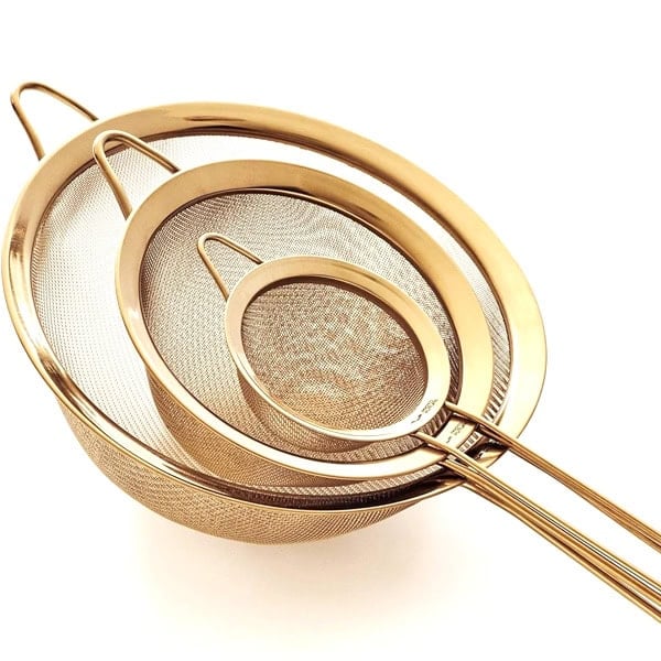 Set of three gold mesh strainers for smoothies and juices.