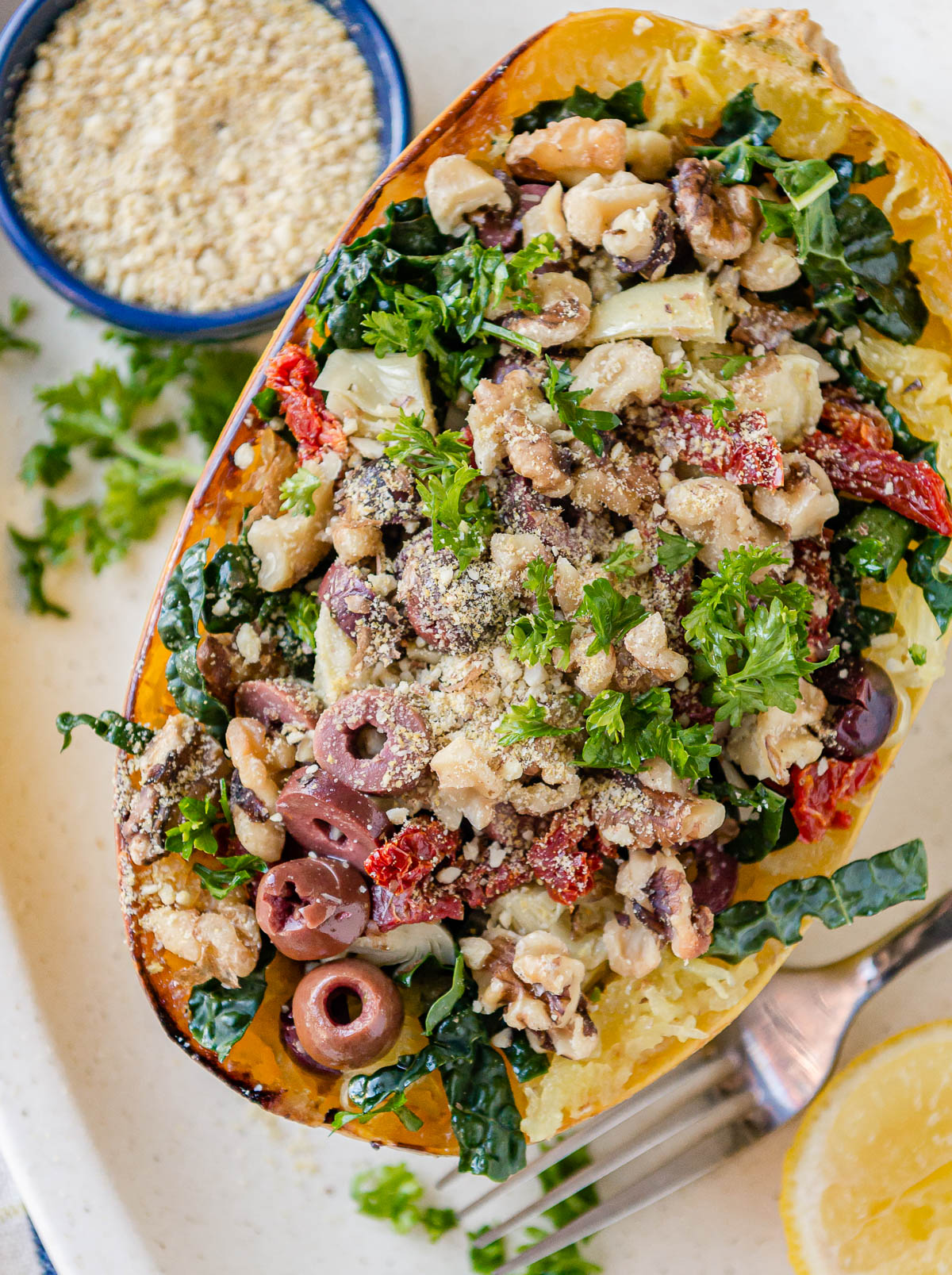 spaghetti squash topped with sun-dried tomatoes, kale, walnuts, parsley, olives and vegan cheese.