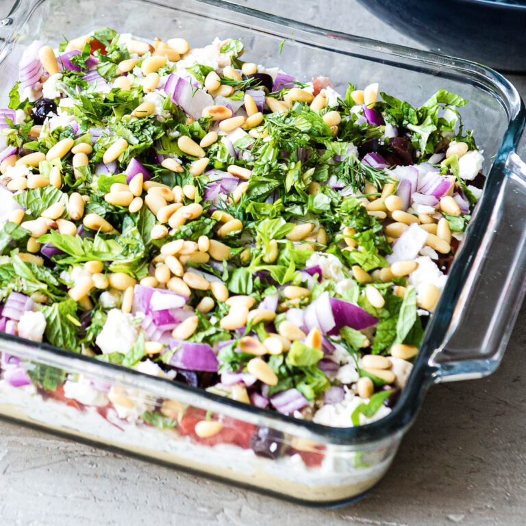 Layered Greek dip in glass dish