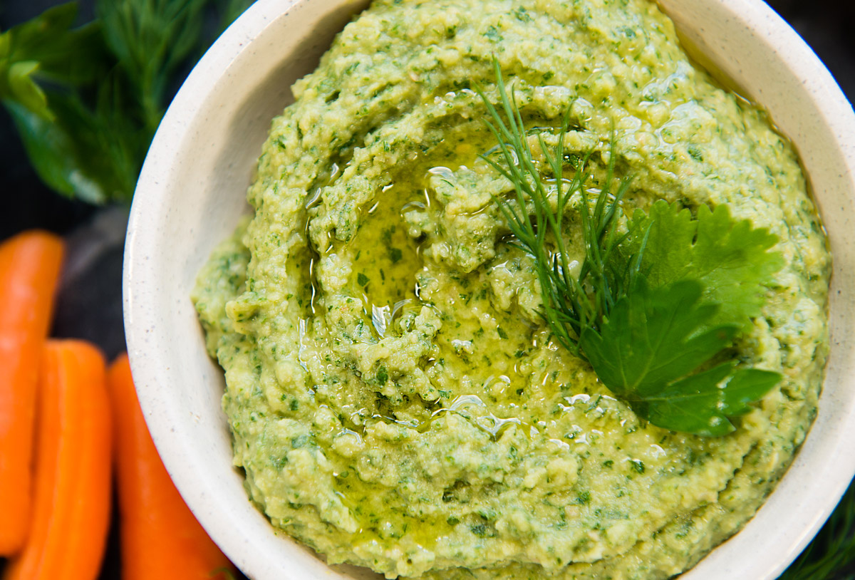 Close up hummus with chopped dill, parsley and cilantro.
