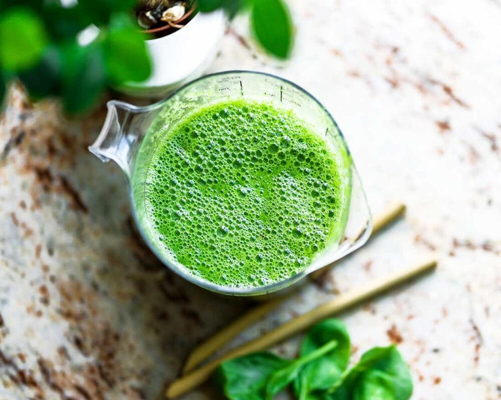 blender container full of green smoothie.