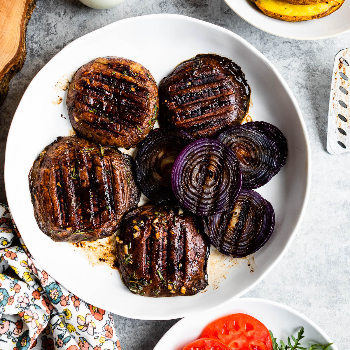 Grilled Portobello mushrooms and onions on a white plate