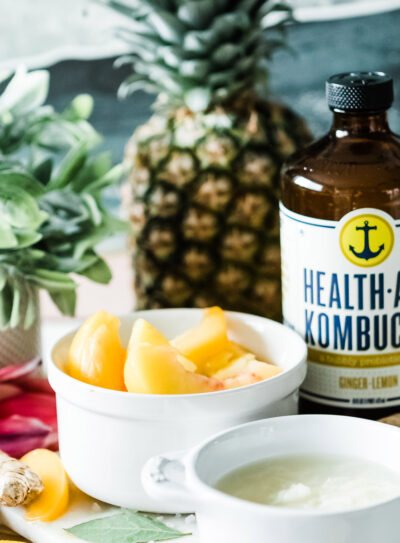 Kombucha smoothie with a gut health plant based foods surrounding it in kitchen.
