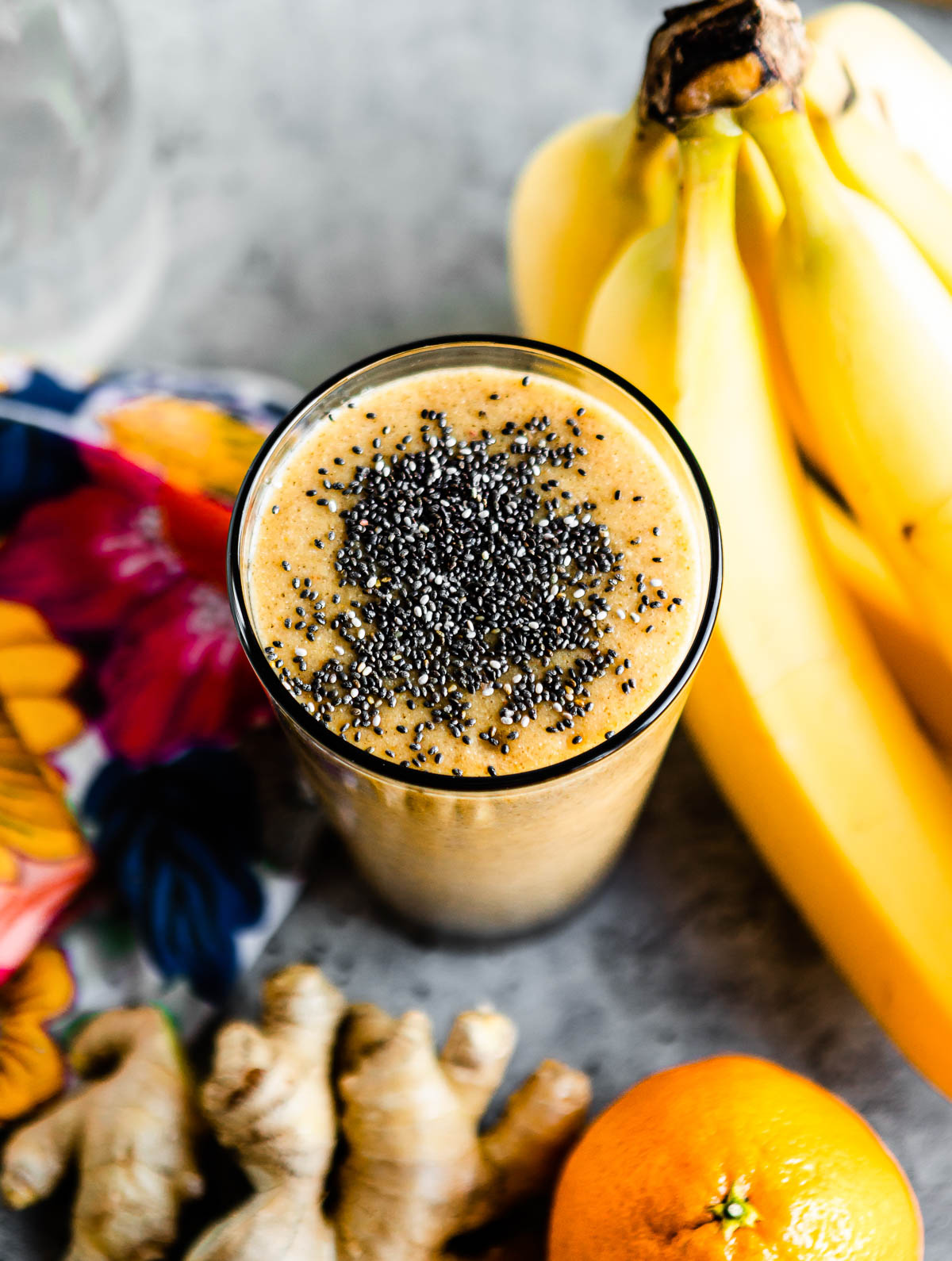 orange hangover smoothie in glass topped with black chia seeds.