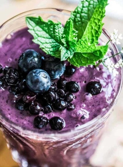 blueberry smoothie topped with blueberries and fresh mint.
