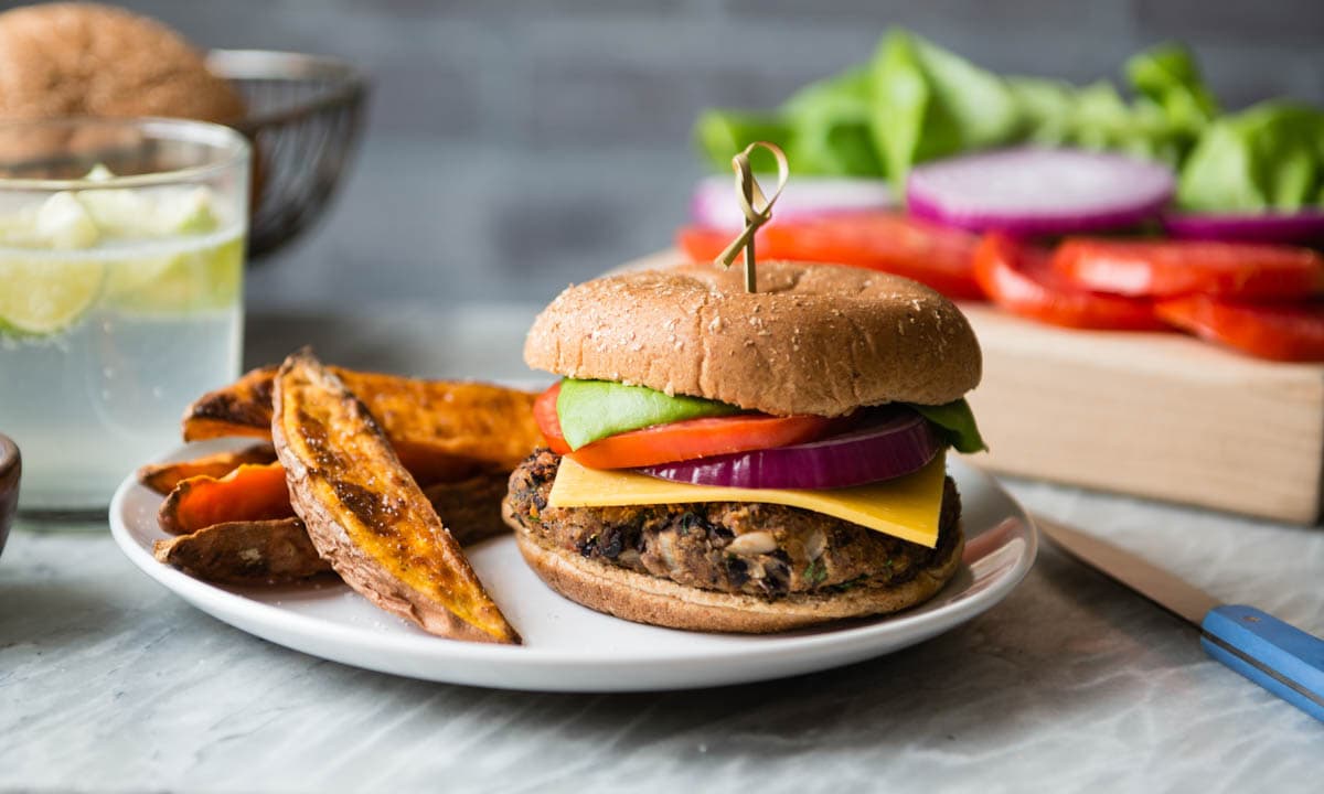 delicious food for a party shown including a black bean burger and sweet potato fries