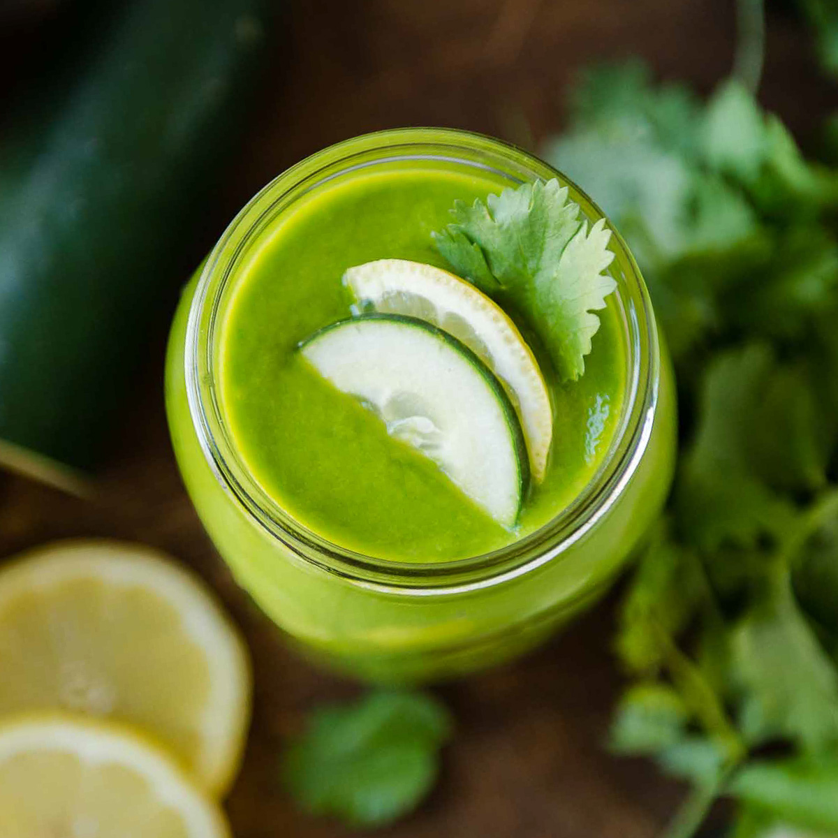 A top-down view of a healthy fat smoothie garnished with cucumber and parsley.