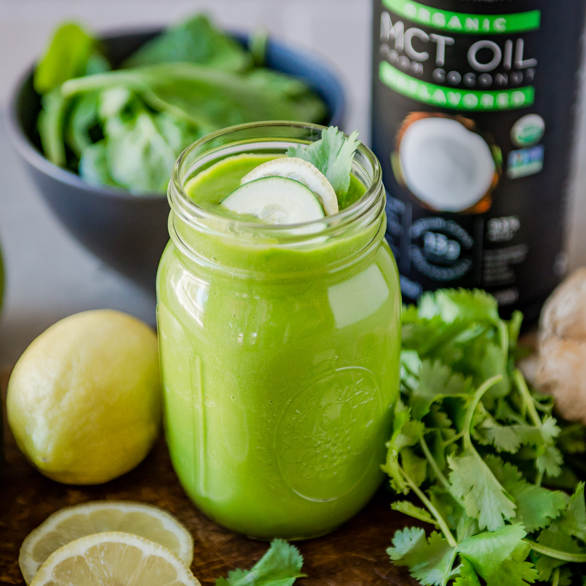 Healthy fat smoothie next to fresh ingredients and a bottle of MCT oil