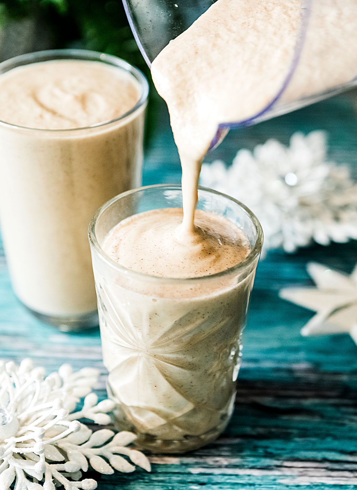 Pouring gingerbread smoothie recipe into a glass.