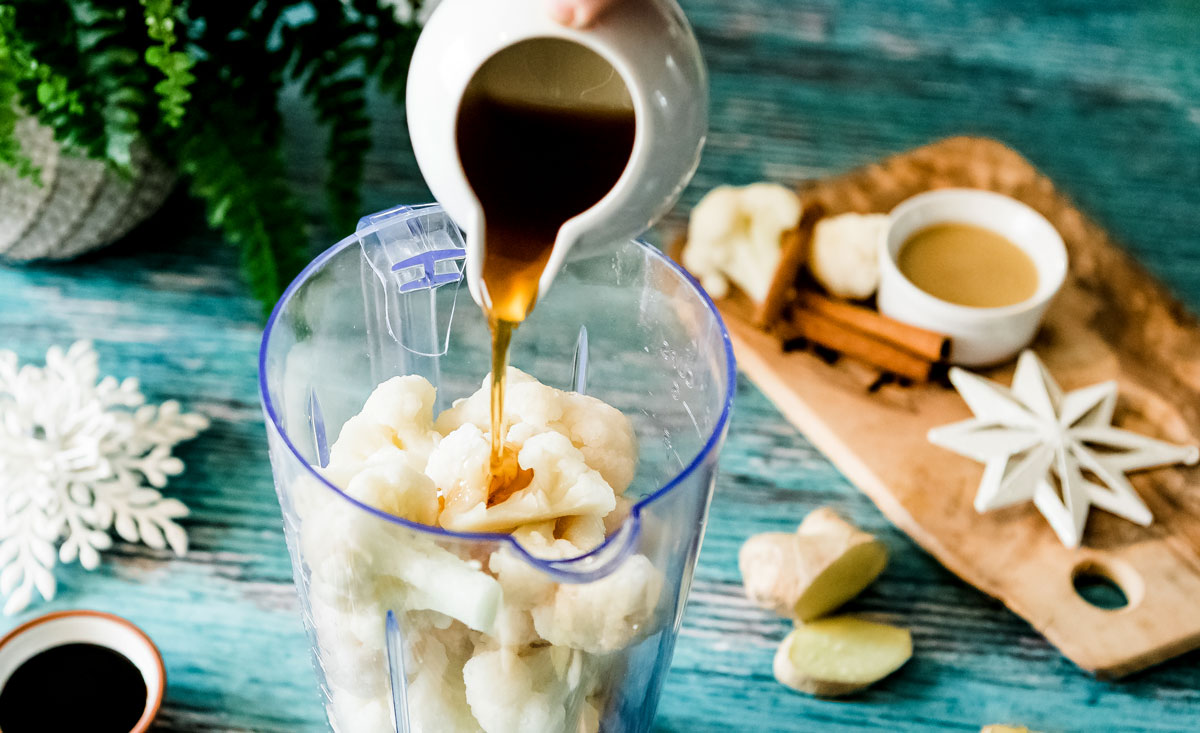 Preparing a healthy gingerbread smoothie recipe in a blender.