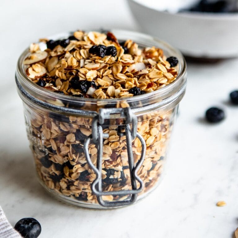 healthy granola in a glass jar with dried blueberries.