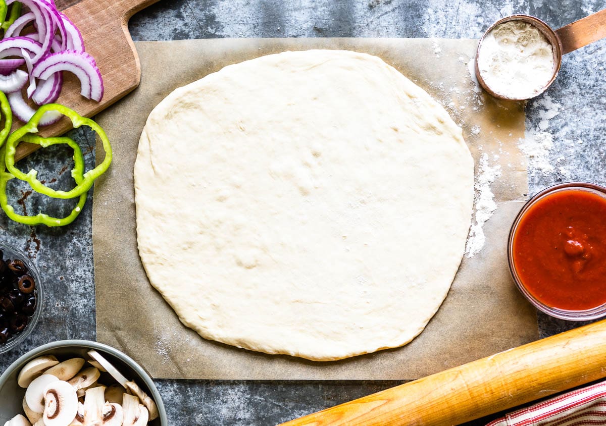 homemade pizza crust tossed and ready to be topped with sauce and toppings.