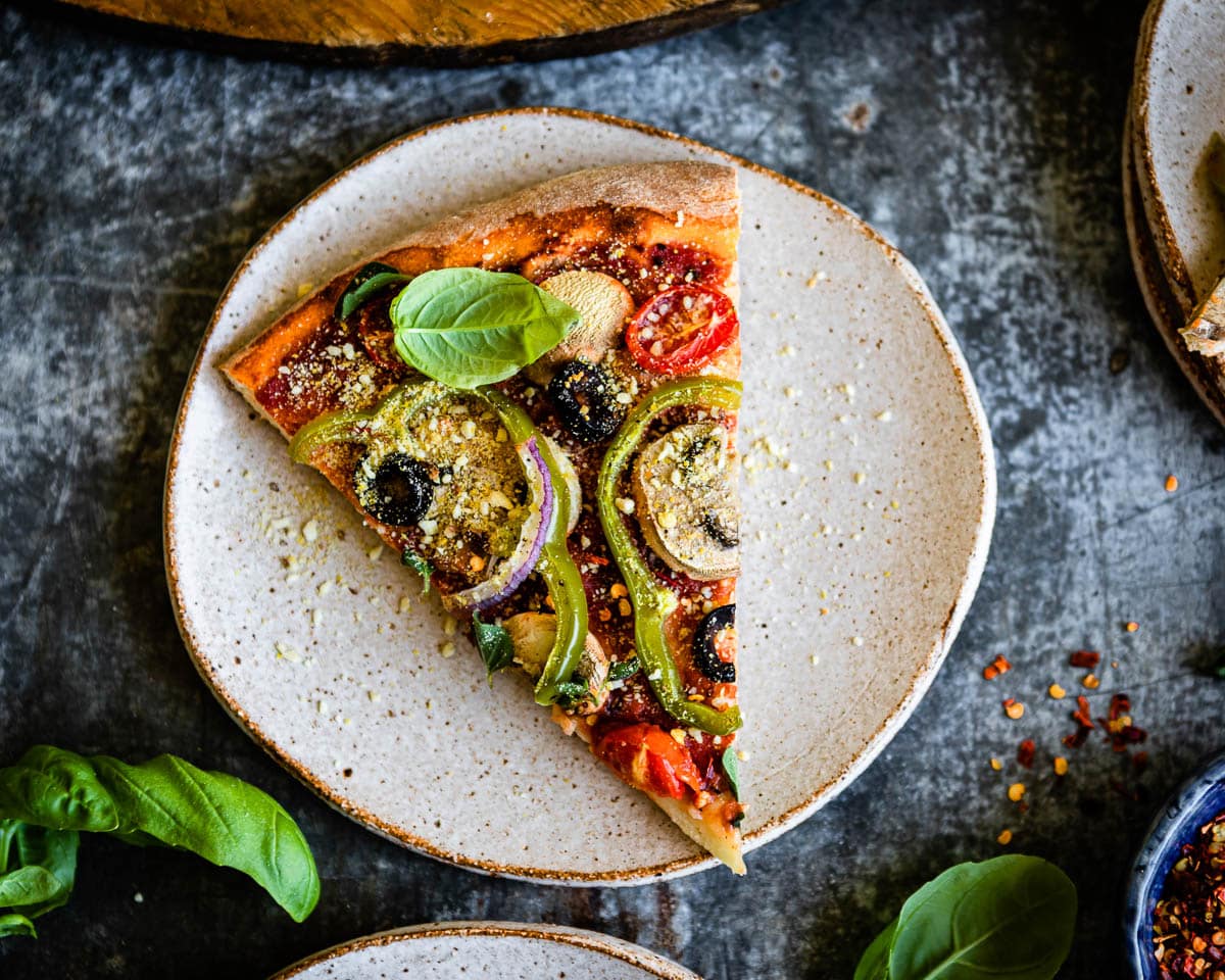 classic vegetarian pizza slice on a ceramic plate.