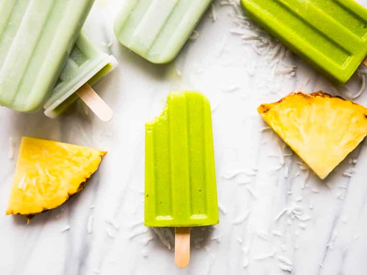 Green smoothie popsicles on marble board