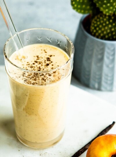 homemade protein shake in glass with glass straw.