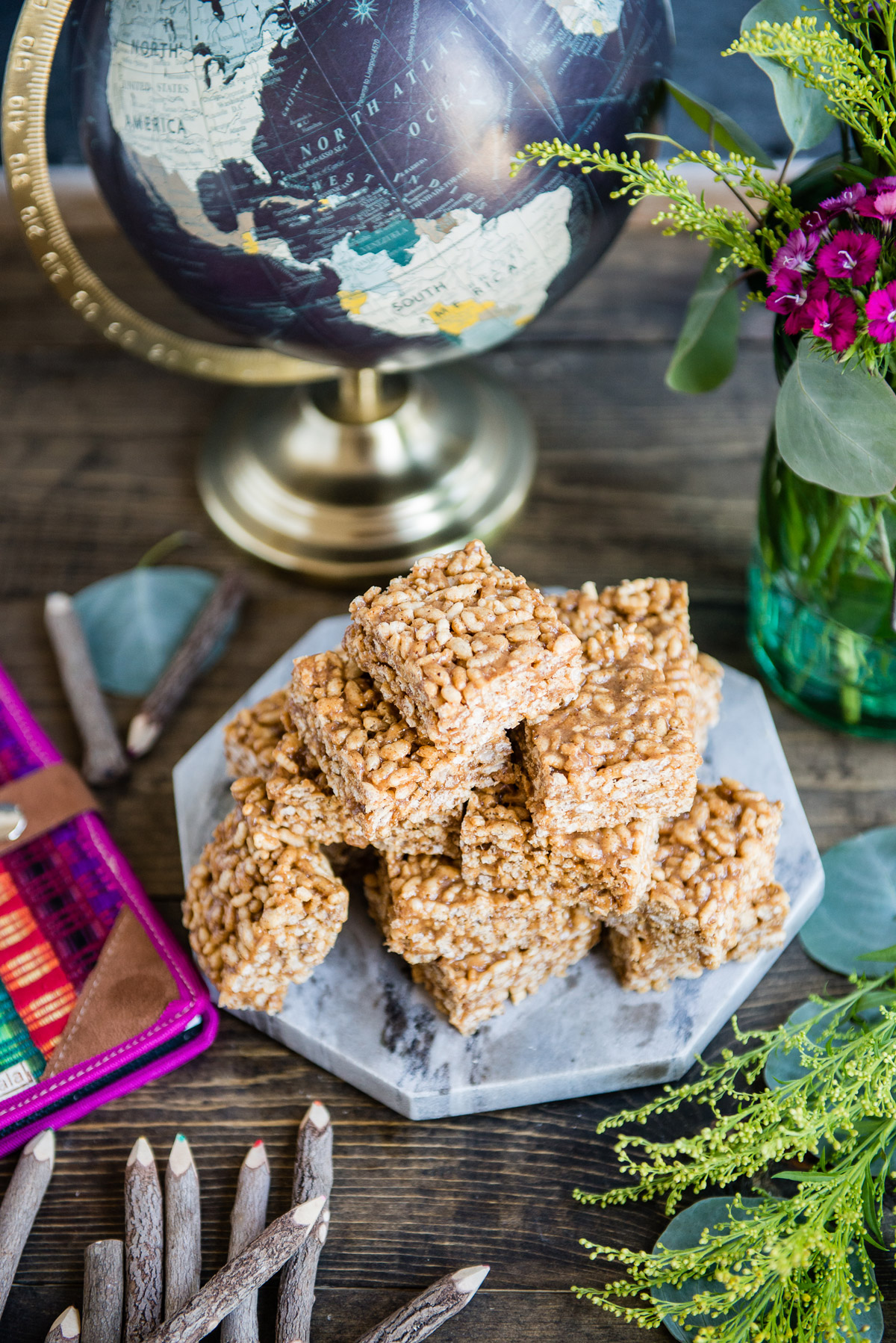 Freshly made healthy rice krispie treats in bars stacked on a wood table.