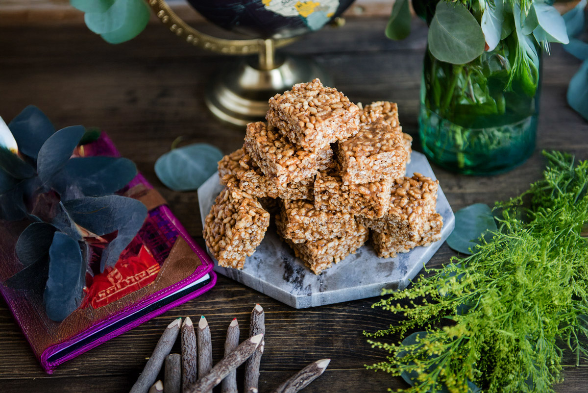 Freshly made healthy rice krispie treats in bars stacked on a wood table.