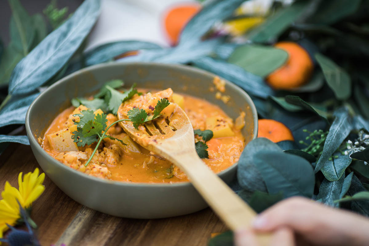 A bowl of soup with a wooden spoon