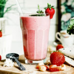 healthy strawberry smoothie in glass with straw