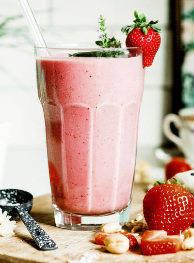healthy strawberry smoothie in glass with straw