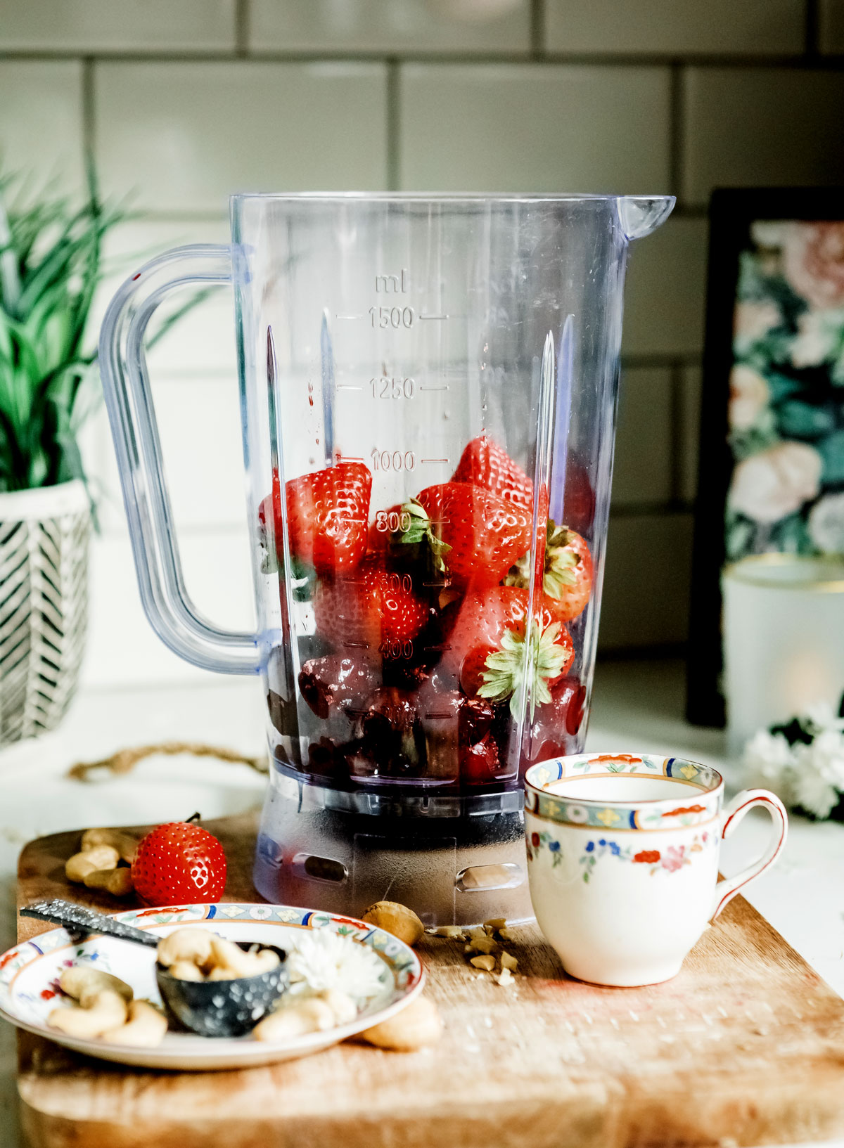 blender with ingredients to make strawberry smoothie.