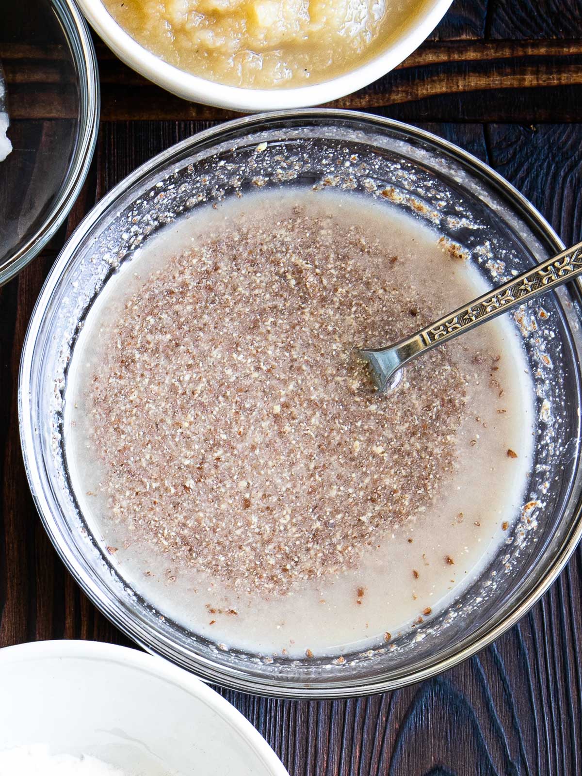 glass bowl with flax egg mixture and a silver spoon.