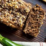 Partially-sliced loaf of zucchini bread.