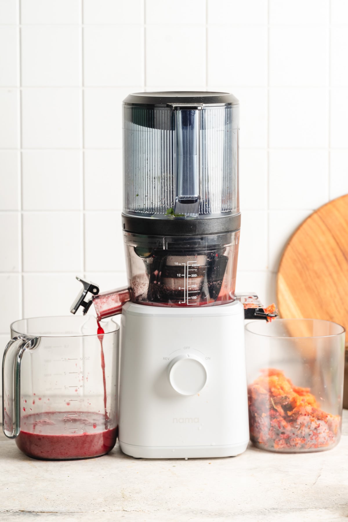 Left container filled with fresh juice, while pulp collects in a right container