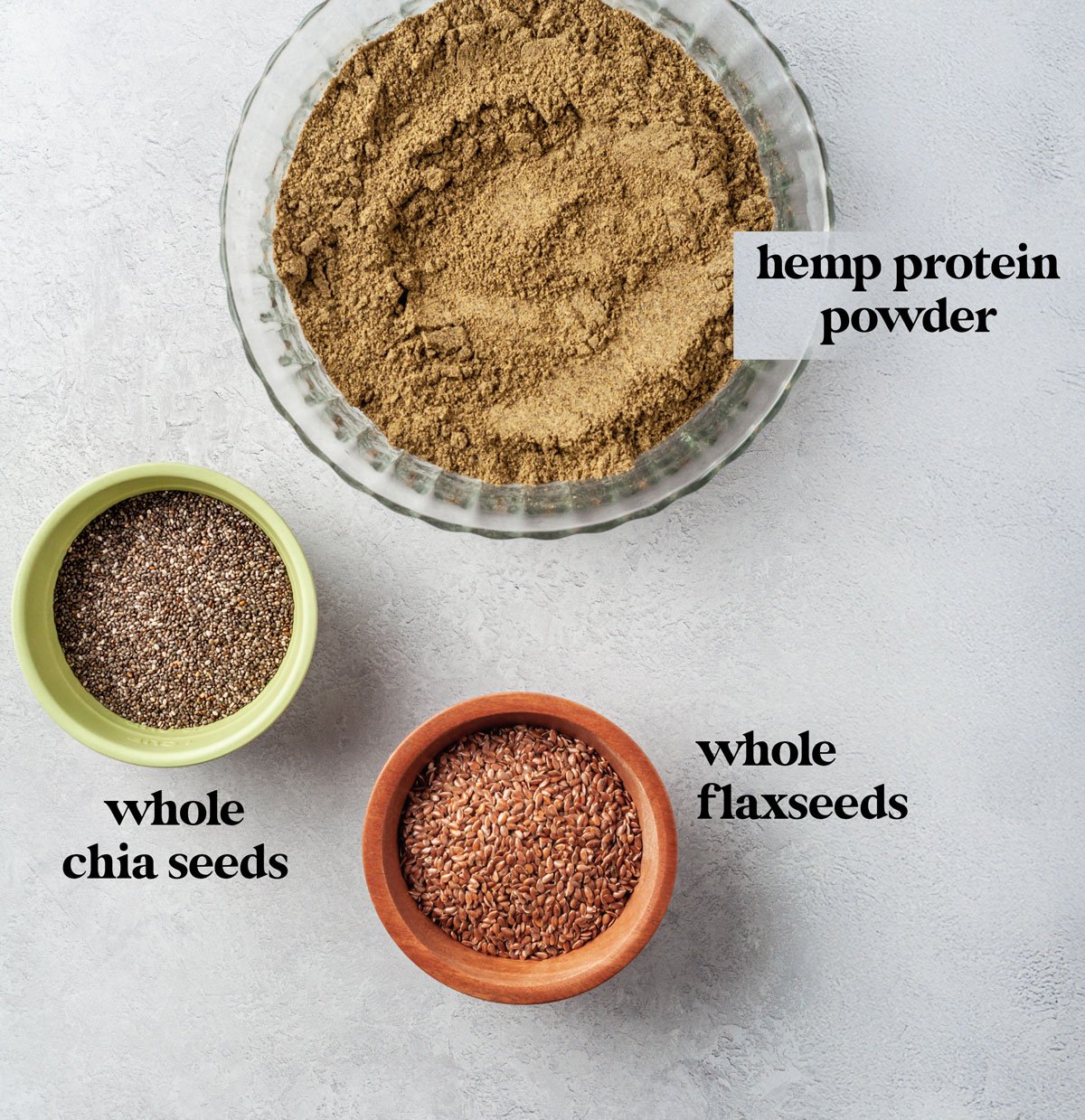 Labeled ingredients to make homemade protein powder recipe with chia seeds, hemp protein and flaxseed.