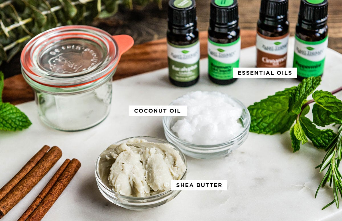 ingredients for vapor rub including essential oils, coconut oil and shea butter, written over the ingredients themselves. 