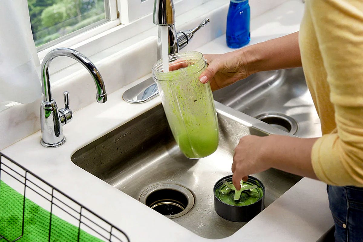 Woman cleaning nutribullet blender in sink