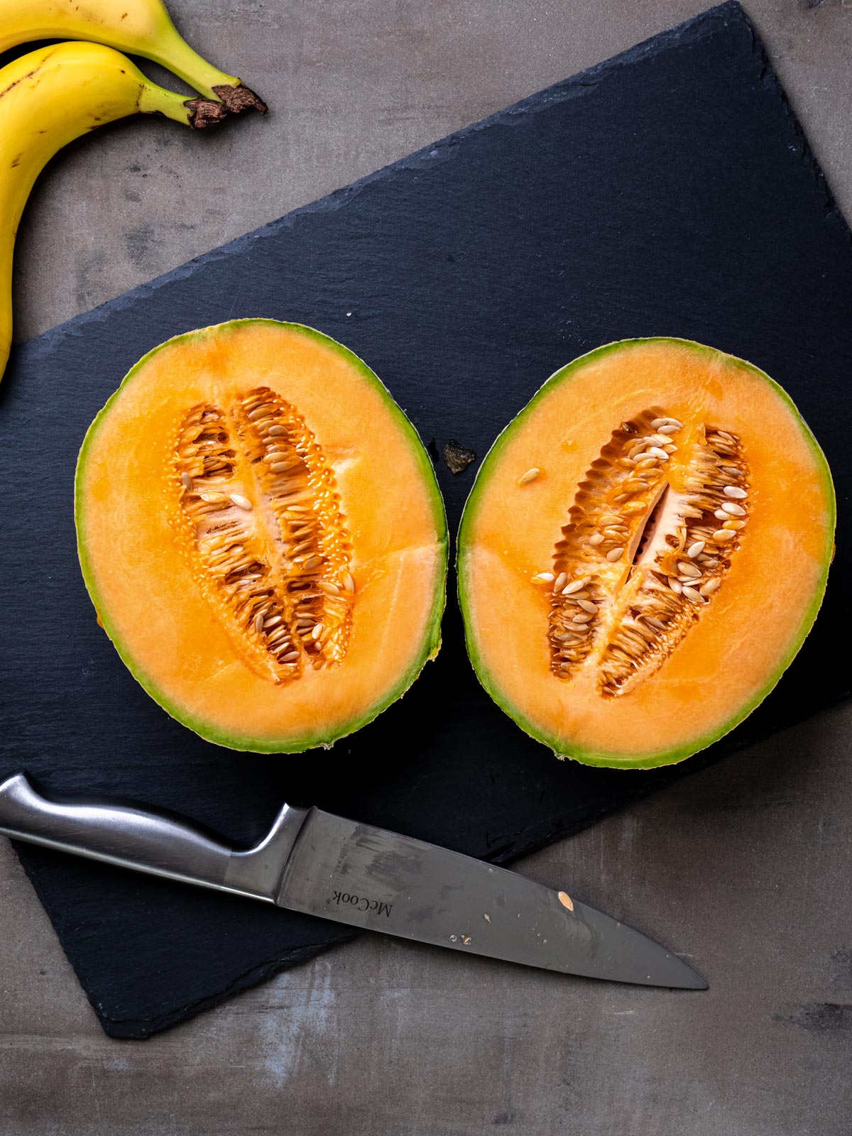 Fresh cantaloupe on cutting board with knife for tutorial