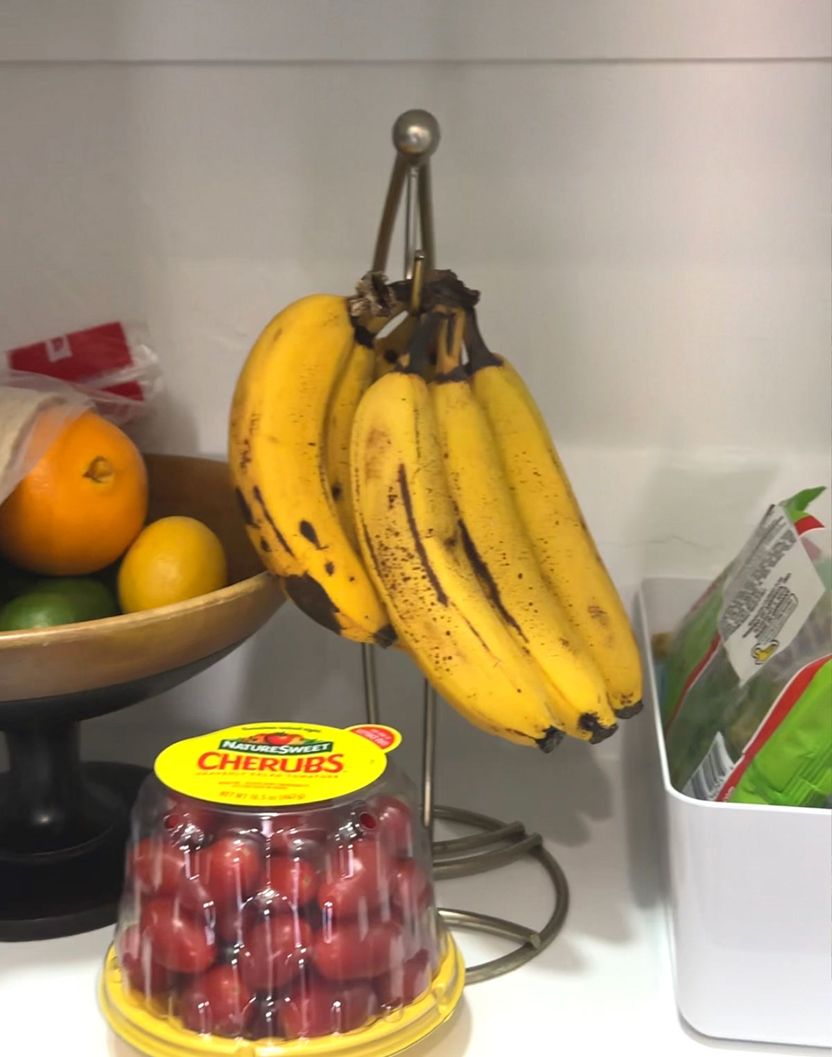 Ripe bananas in pantry with bowl of tomatoes