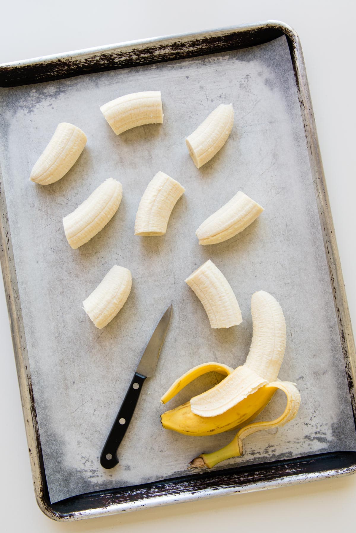 chopped banana pieces on a parchment lined tray