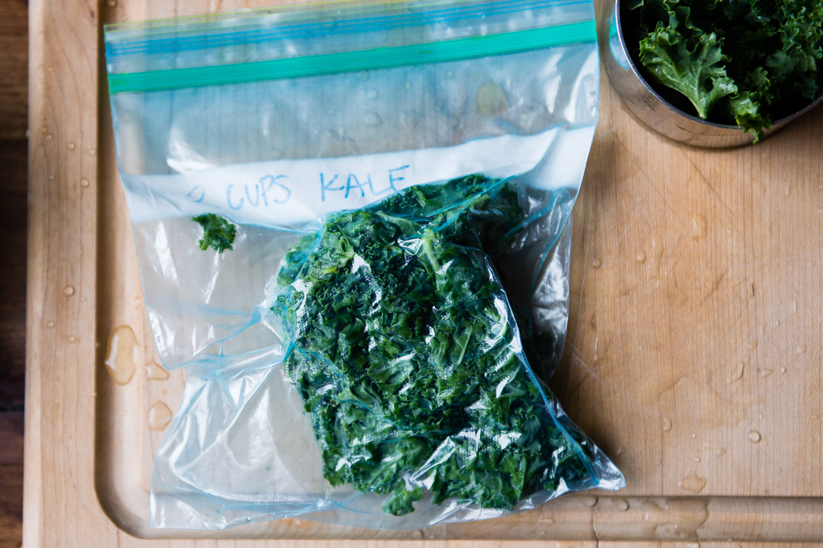 A bag of kale with the air pressed out, sealed for freezing