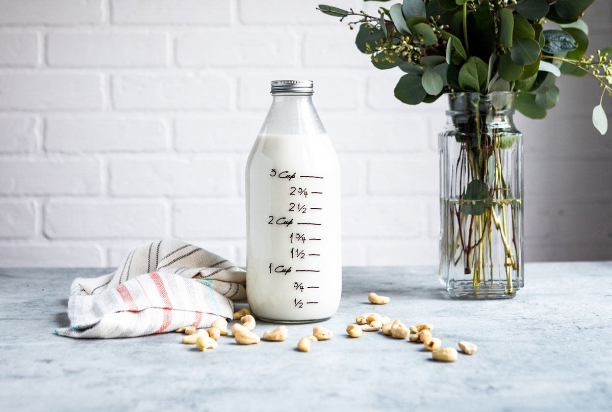 Cashew milk recipe in a glass jar with measurement markings.