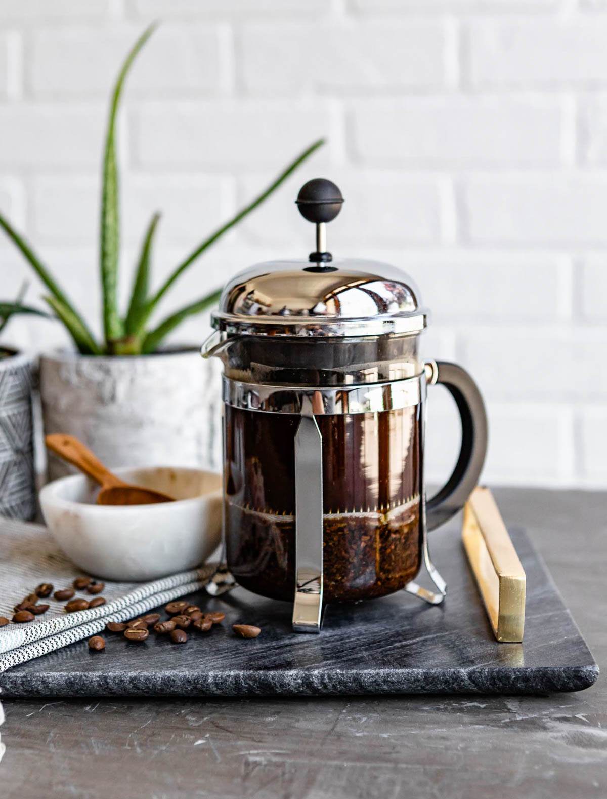 french press full of coffee grounds and water.