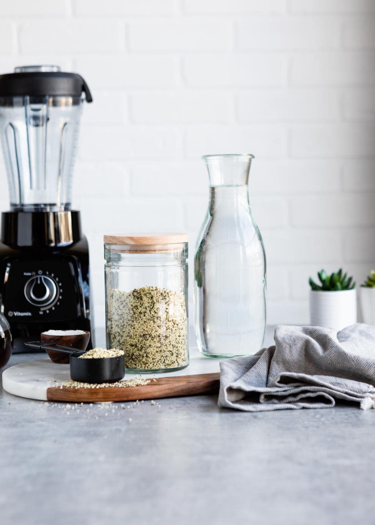 hemp hearts and water on a counter with a blender in the background
