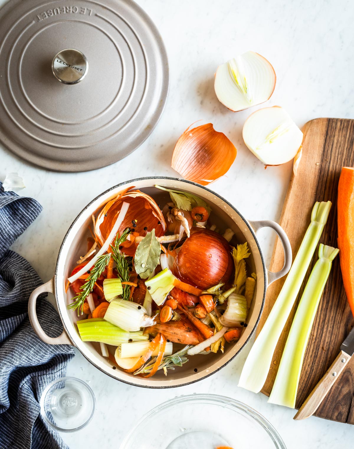 ceramic stock pot full of vegetable scraps, water and spices.